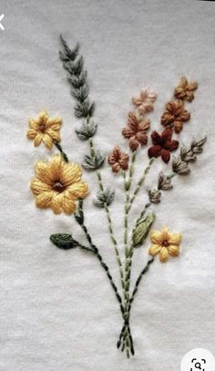 a bunch of flowers that are sitting on a table cloth with some thread in it