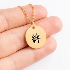 BOND Incorporating Japanese characters into your personalized coin necklace adds a unique and elegant touch that is both meaningful and visually stunning. Japanese letter/character/kanji, 絆(kizuna) means BOND. It represents the strength, trust, and love that forms the foundation of your relationship. A beautiful gift to celebrate your commitment and the cherished moments you've shared. The fluid strokes and intricate details of Japanese script add an artistic flair, turning it into a timeless ke Symbolic Customizable Necklace For Gift, Symbolic Personalized Necklaces For Friendship, Personalized Symbolic Necklaces For Friendship, Symbolic Personalized Good Luck Necklaces, Good Luck Symbolic Necklace With Personalized Details, Minimalist Personalized Good Luck Necklace, Spiritual Round Coin Necklace Gift, Spiritual Round Coin Necklace As Gift, Spiritual Coin Necklace As Gift