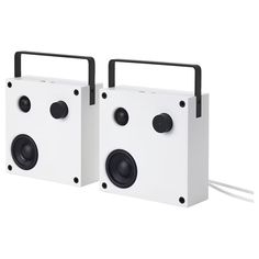 two white speakers sitting next to each other on top of a white surface with black handles