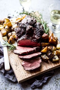 roast beef with potatoes and rosemary on a cutting board