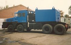 a large blue truck parked in front of a building