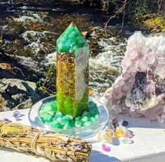 a table topped with green rocks next to a river