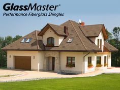 a large house with a green roof and two garages