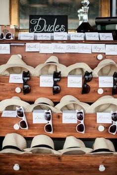 a display case filled with lots of hats and sunglasses on top of a wooden table