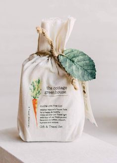 a bag with a leaf attached to it sitting on top of a white countertop