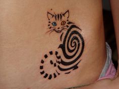 a cat tattoo on the side of a woman's stomach, with spiral designs