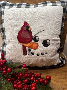 a red cardinal pillow sitting on top of a wooden table