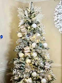 a decorated christmas tree with white and silver ornaments