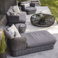 an outdoor seating area with grey wicker furniture