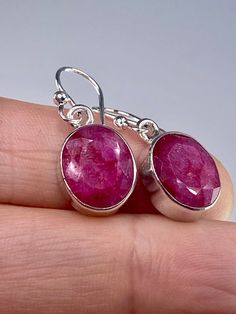 A beautifully sophisticated pair of vivid red Ruby and sterling silver dangle earrings. The feature stone is oval-cut and set in a classic bezel.  Weight - 3 grams ( 1.5 grams each) The earrings measure - 1.2 cm long x 0.9 cm wide and 0.3 cm deep. Drop is - 3.0 cm. Product made hypoallergenic with pure 925 silver that is nickel free. About the Stone: Most of the 'big three' gemstones - emeralds, rubies and sapphires - are in some way enhanced or treated. Only the very pure, perfectly coloured and flawless can escape any type of enhancement, and this is reflected in their record-breaking prices. The ruby is a lustrous, deep red stone that has accrued special and symbolic meaning through time. Through the ages, the ruby has represented nobility, purity, and passion. From ancient times throug Linking Rings, Sterling Silver Dangle Earrings, Red Stone, Silver Earrings Dangle, Etsy Earrings Dangle, Heart Chakra, Sterling Silver Pendants, Silver Pendant, Ruby