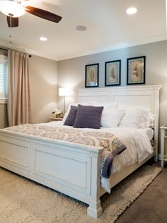 a large white bed sitting in a bedroom next to two lamps on either side of the bed