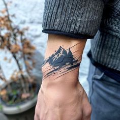 a man with a mountain tattoo on his wrist