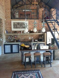 an open kitchen and dining area with stairs leading up to the loft