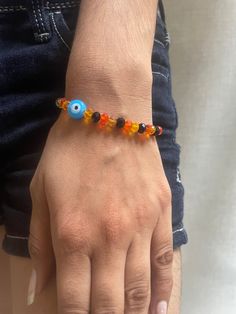 a person wearing a bracelet with an evil eye beaded on it's wrist