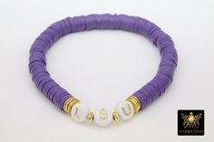 Purple and Gold Bracelet in Heishi Beads by Regina Harp Designs These bracelets are in a purple, white and gold colors with your choice of bracelet style. They can be made with our other bead colors as well; message us if you would like to customize your bracelet. If you need a smaller or extra large size in the bracelet, please leave us a note with your order. To measure your wrist size you can wrap a piece of string around your wrist and mark it. Then lay the string down and see how long it is White And Gold Bracelet, Beaded Bangles, White Jewelry Box, By Regina, Bracelet Style, Bead Bangles, Gold Colors, Small Charms, Stretchy Bracelets