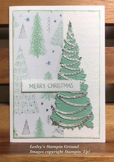 a christmas card with a green tree on the front and white lettering that says merry christmas