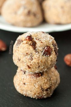 two cookies stacked on top of each other with almonds in the background and another plate behind them