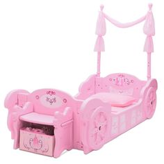 a pink toy bed with princess furniture and accessories