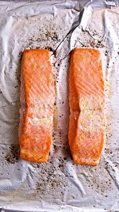 two salmon fillets sitting on top of aluminum foil