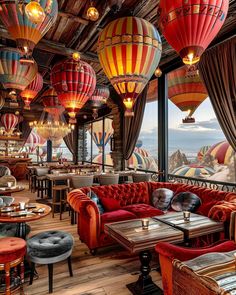 a restaurant with red couches and hot air balloons hanging from the ceiling above them