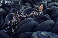 a woman laying on top of a pile of tires