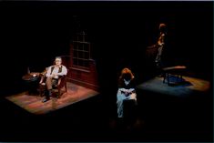 three people sitting in chairs on a stage