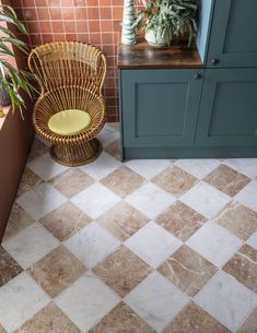 a chair sitting on top of a tiled floor next to a potted plant