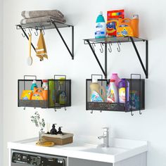 two black metal shelfs holding cleaning products and other household items on the wall next to a washer and dryer