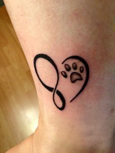 a dog's paw and heart tattoo on the ankle