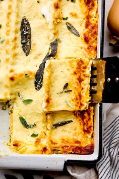 a square casserole dish with cheese and herbs