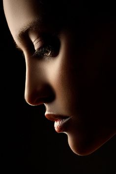 a woman's face is lit up by the light from her eyes and nose