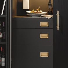 a black cabinet with gold handles and drawers