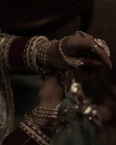 a close up of a person's hands with bracelets