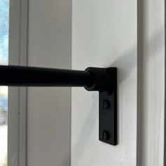 a close up of a black handle on a white door