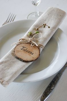 a white plate topped with a piece of wood next to a fork and knife holder