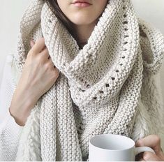 a woman wearing a scarf and holding a coffee mug