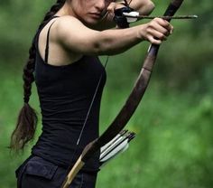 a woman is aiming with her bow and arrow