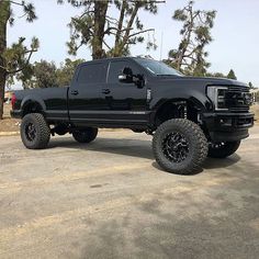 a large black truck parked on top of a parking lot