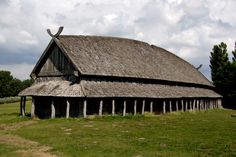 an old wooden barn with a thatched roof