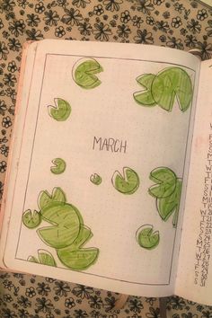 an open book with drawings of green plants and the words march written in japanese on it