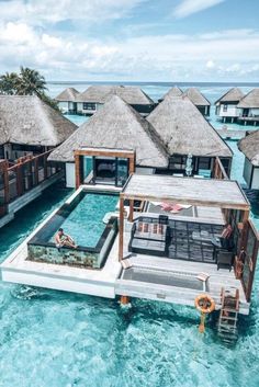 the water villa is surrounded by thatched huts