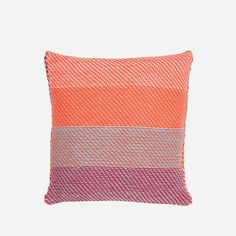 an orange and pink pillow on a white background with the color block in red, grey, and blue