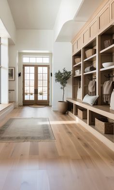 a large open living room with wooden floors and built in bookshelves on either side of the door