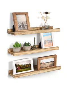 three wooden shelves with pictures and plants on them