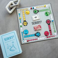 a board game sitting on top of a table next to a book and some scissors