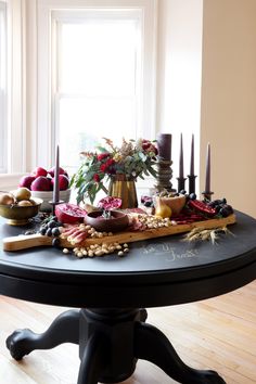 a table with candles, fruit and flowers on it