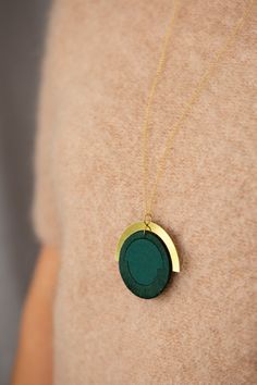 "I have designed the pieces in this collection to be easy to wear with anything. I wanted to focus on the shapes and composition of the pieces themselves as opposed to the stitches on them. This circular pendant is made from Forest Green cotton which has been interfaced to provide structure. I have bound the edges in a band with a matching embroidery thread in Forest Green. This is joined to a brass arc which is hung from a long 30\" chain of Gold Vermeil . The pendant measures 50x50mm. All find Modern Green Circular Jewelry, Modern Green Necklace With Round Pendant, Modern Green Round Pendant Necklace, Modern Handmade Circular Necklace, Chain Of Gold, Matching Embroidery, Circle Pendant, Green Cotton, Embroidery Thread