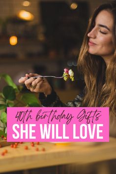 a woman holding a fork and looking at her birthday cake with the words she will love on it