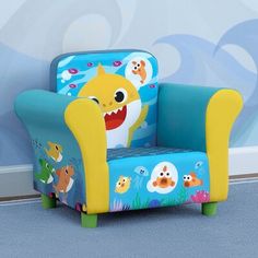 a kid's chair with a cartoon shark on it, sitting in front of a wall