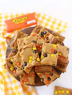 a wooden plate topped with brownies covered in candy